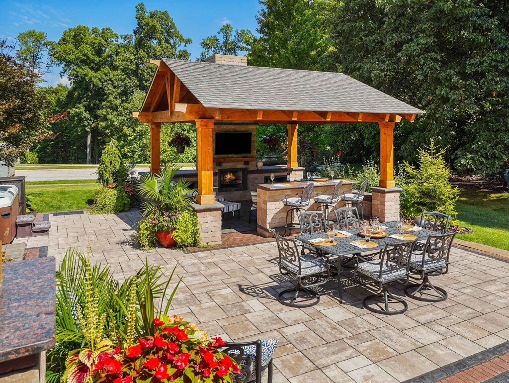 detached-patio-with-chair-firplace-surrounded-by-green-vegetation-and-flower-vases-scaled